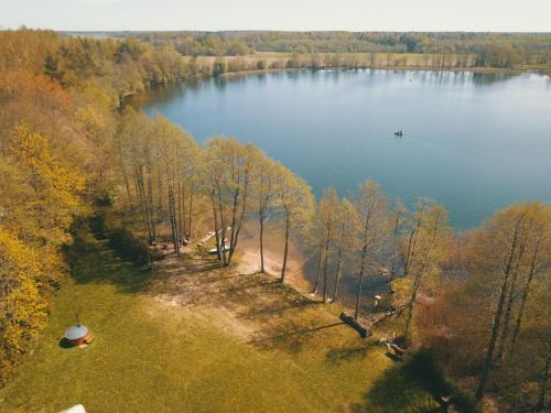 an aerial view of a lake with a boat in it at Palapinė medyje in Barkellai