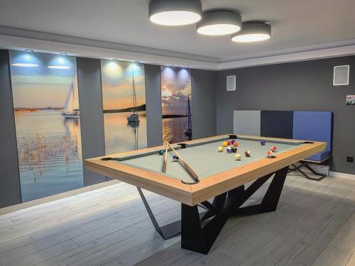 a pool table in a room with a view of the water at Cobalt Apartments in Mikołajki