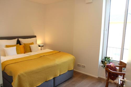 - une chambre avec un grand lit et une couverture jaune dans l'établissement Mosel-Loggia - Luxusapartment -Terrass - Klimaanlage, à Traben-Trarbach