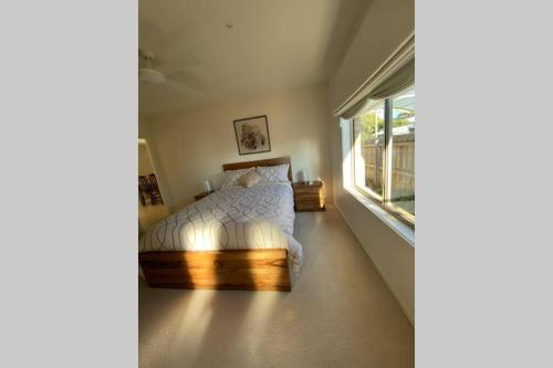 um quarto com uma cama e uma janela em Sun-lovers Beach House - Walk to beach/shops! em Rosebud
