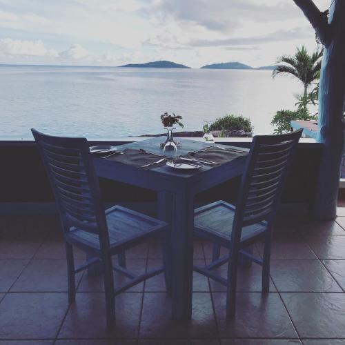 a table with chairs and a view of the ocean at Hotel L'Ocean in La Digue