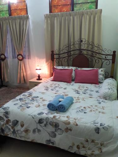 a bedroom with a bed with two blue towels on it at Anjung Nor Muslim Homestay in Dungun