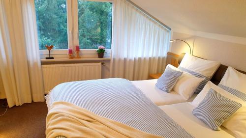 a hotel room with two beds and a window at Gästehaus Sonnenhügel in Möhnesee