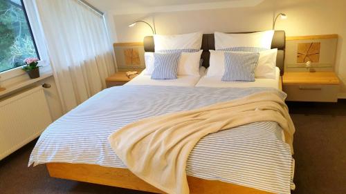 a bedroom with a large bed with two pillows at Gästehaus Sonnenhügel in Möhnesee