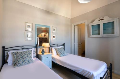 a bedroom with two beds and a mirror at Caveland in Karterados