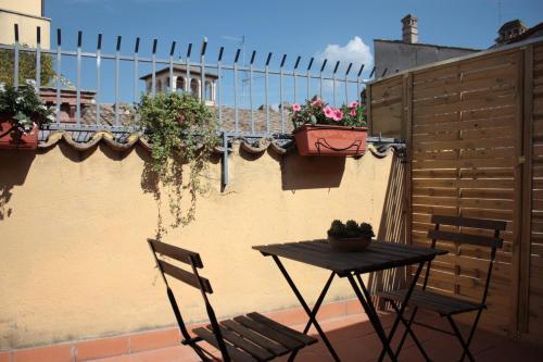 a table and chairs on a balcony with plants at Affittacamere Arco Polinori in Foligno