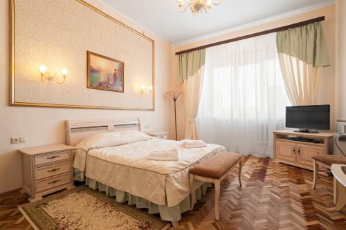 a bedroom with a bed and a television in it at Petrovskaya Hotel in Shlisselburg