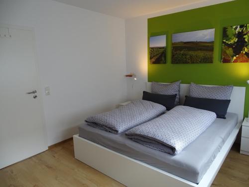 a bedroom with a bed with green and white walls at Rheinhessen Apartment in Nieder-Olm