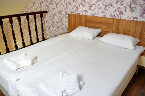 a large white bed with two white pillows on it at Forest Nook Aparthotel in Pamporovo