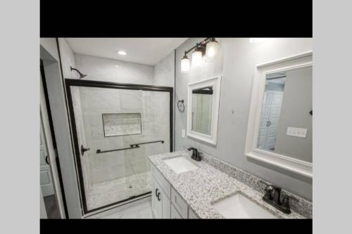 a white bathroom with two sinks and a shower at 10 mins from Downtown New Orleans *a must see * in New Orleans