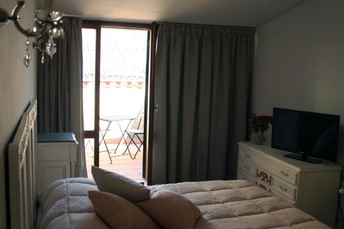 a living room with a bed and a television and a balcony at Affittacamere Arco Polinori in Foligno