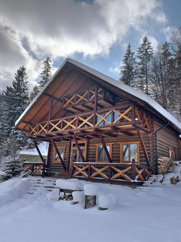 a large log cabin in the snow with trees at Терношорська Лада in Snidavka
