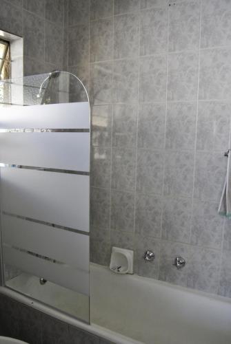 a bathroom with a white tub and a mirror at Stop-a-While in Krugersdorp