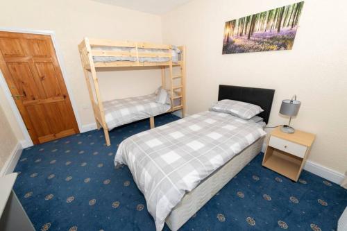 ein Schlafzimmer mit einem Bett und einem Etagenbett in der Unterkunft The Bungalow at Seaway's, Sleeps 11 + in Great Driffield