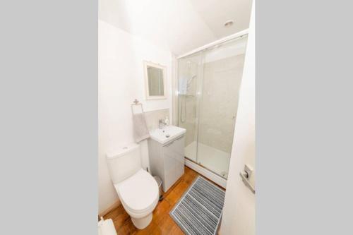a white bathroom with a toilet and a shower at The Bungalow at Seaway's, Sleeps 11 + in Great Driffield