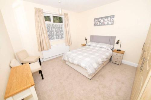 a bedroom with a bed and a desk and a window at The Bungalow at Seaway's, Sleeps 11 + in Great Driffield