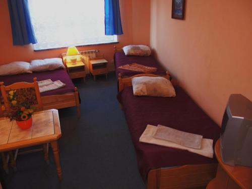 オレツコにあるHotelik Centrumのベッド2台、テーブル、窓が備わる客室です。