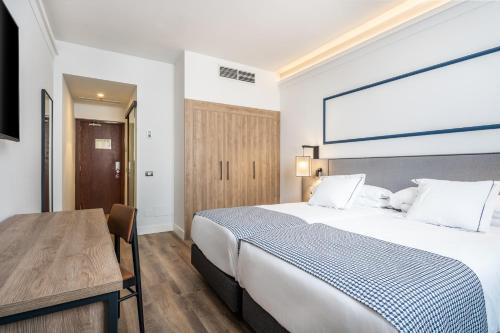 a bedroom with a large bed and a wooden table at Hotel LIVVO Fataga in Las Palmas de Gran Canaria