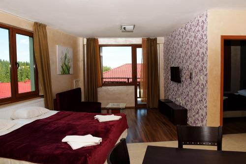 a hotel room with a bed and a table and chairs at Forest Nook Aparthotel in Pamporovo