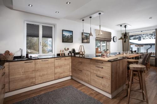 a kitchen with wooden cabinets and a large island at Chalet Schmitten 102 by Chalet Alp Lux - Opposite ski lift in Zell am See
