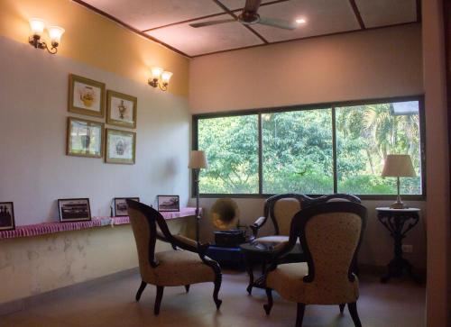 a living room with a table and chairs and a window at Puroni Bheti Tea and Farm Retreat in Jorhāt
