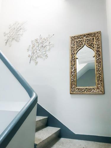 a mirror on a wall next to a staircase at Pensión Casa do Gallo Sarria in Sarria