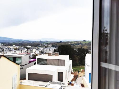 a view of a city from a window of a building at Pensión Casa do Gallo Sarria in Sarria