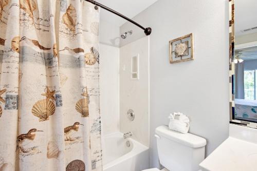 a bathroom with a toilet and a shower curtain at Ciboney 2015 in Destin