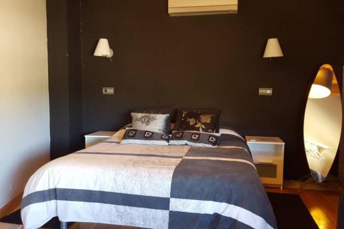 um quarto com uma cama grande e paredes pretas em Casa Ambiente Rural: En plena Ribera del Duero em Mélida