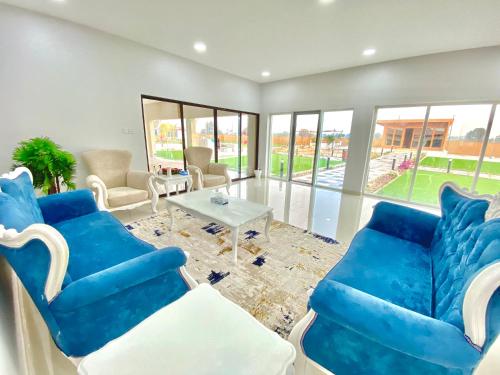 a living room with blue chairs and a table at Seven Elements Resort in Ras al Khaimah