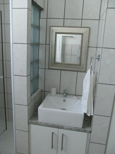 a bathroom with a white sink and a mirror at Casa Bianco in Montagu