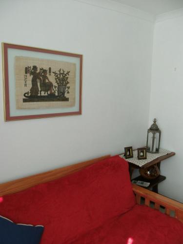 a living room with a red couch and a picture on the wall at Casa Bianco in Montagu