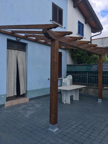 a wooden pergola with a bench on a patio at Casa con giardino vicino al mare in Massa