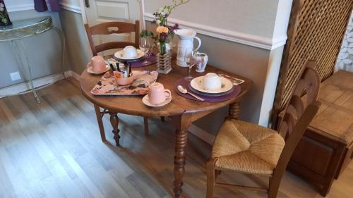 " Le Cher Passant " في Savonnières: طاولة خشبية عليها صحون واكواب وصحون