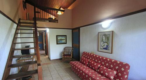 a living room with a red couch and a staircase at Portal Lençóis in Lençóis