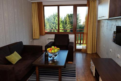 a living room with a couch and a table at Forest Nook Aparthotel in Pamporovo