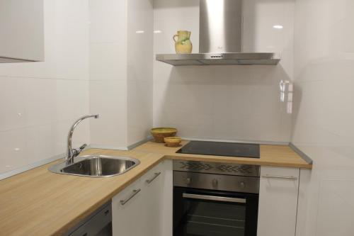 a kitchen with a sink and a stove at Apartamentos rurales 'Los Soportales' in Tendilla
