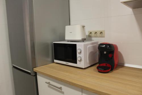 a microwave sitting on top of a counter in a kitchen at Apartamentos rurales 'Los Soportales' in Tendilla