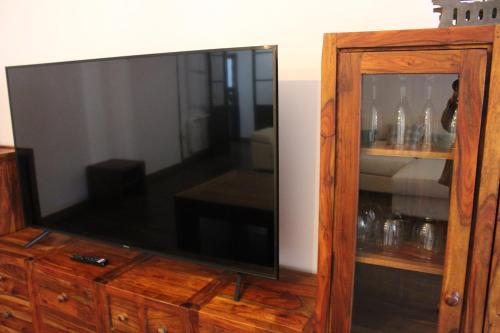 a large flat screen tv sitting on top of a wooden cabinet at Apartamentos rurales 'Los Soportales' in Tendilla