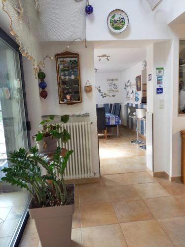 une chambre avec une plante en pot et une horloge sur le mur dans l'établissement Petit Châtelet bis, à Hirel