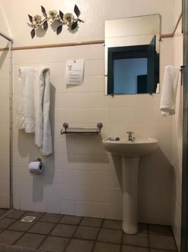 a bathroom with a sink and a mirror and towels at Hotel Fazenda Pirapetinga in Piranga