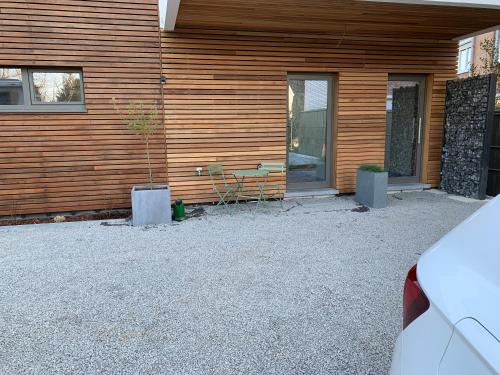 Green studio-Situé à 15 min de Botrange, Parc Hautes Fa gnes et Francorchamps في Heusy: منزل أمامه طاولة وكراسي