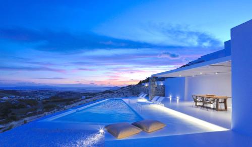 a villa with a swimming pool with a sunset at Pili Pala Suites in Episkopianá
