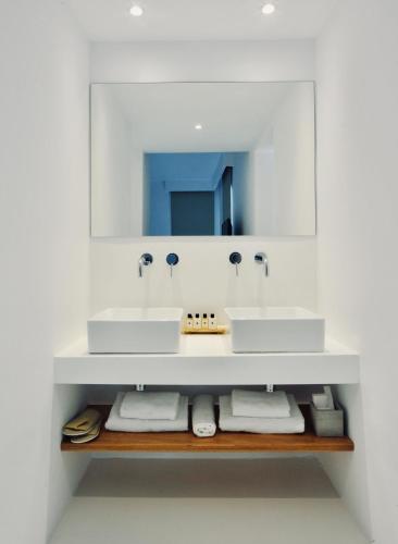a bathroom with two sinks and a mirror at Pili Pala Suites in Episkopianá