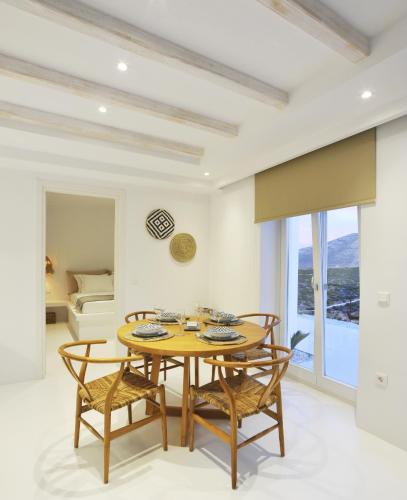 a dining room with a table and chairs and a bed at Pili Pala Suites in Episkopianá