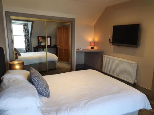 um quarto de hotel com duas camas e uma televisão de ecrã plano em House by the Harbour - NC500 Route em Wick