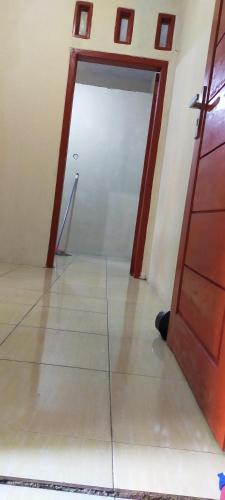 an empty room with a door and a tile floor at Aqsa Guest House Banjarsari in Banjarsari