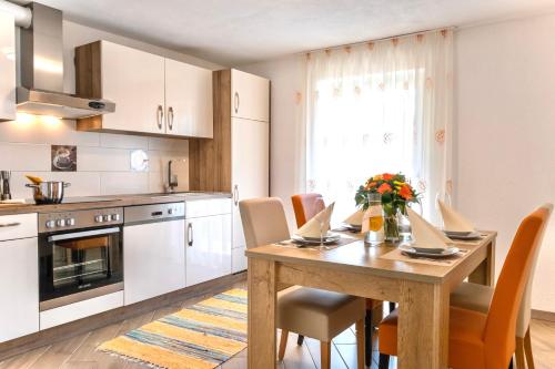 a kitchen with a wooden table with chairs and a dining room at Apartments Davydov in Bad Hofgastein