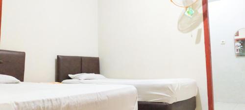 two beds sitting next to each other in a room at Aqsa Guest House Banjarsari in Banjarsari