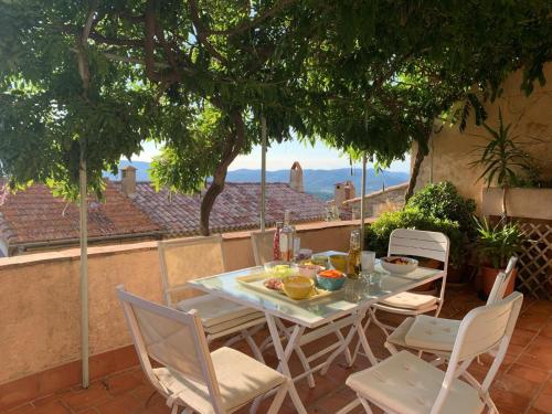 une table et des chaises sur une terrasse avec vue dans l'établissement Maison au cœur du Village, à Gassin
